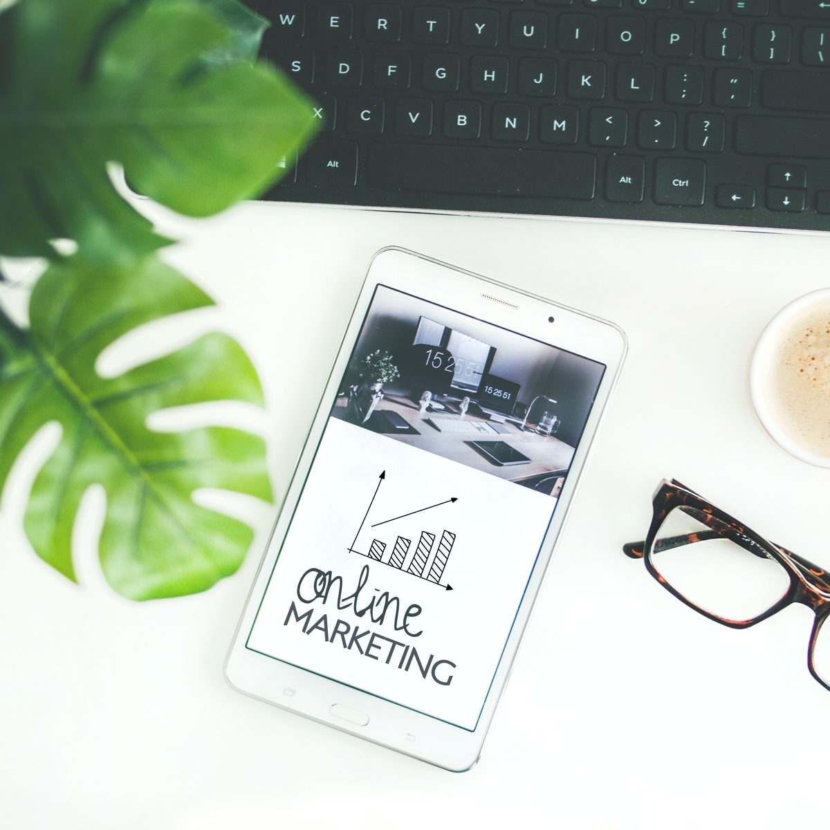Tablet with online marketing illustration on it siting on work desk